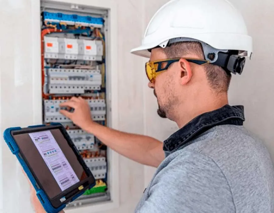 Electricista revisando un tablero eléctrico con interruptores termomagnéticos